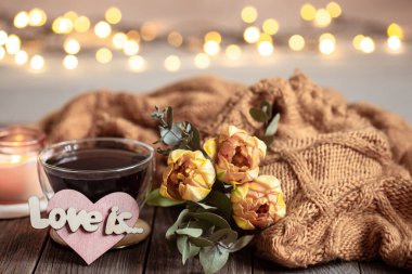 Şen şakrak hayat, bokeh 'li bulanık bir arka plana karşı tahta bir zeminde içkiyle, çiçeklerle ve dekorla bayılıyor..