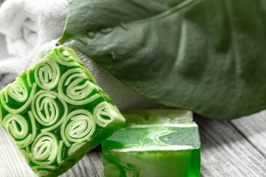 El yapımı sabun, havlu ve büyük yapraklı spa kompozisyonu. Sağlık ve güzellik kavramı.