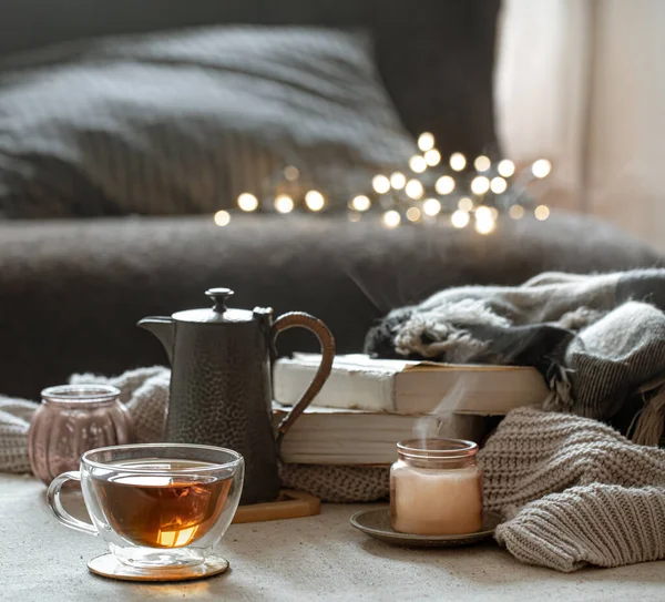 清静的生活 一杯茶 一个茶壶 一本书 烛台上的烛光 背景朦胧而模糊 背景中夹着酒壶 — 图库照片