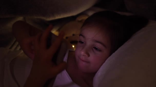 Menina Bonito Assistir Smartphone Cama Criança Entusiasticamente Usando Telefone Jogo — Vídeo de Stock