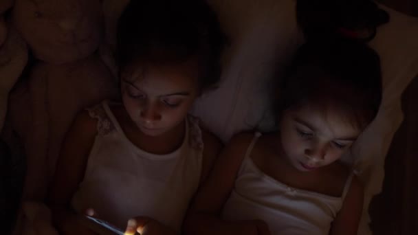 Kislányok Néz Okostelefon Ágyban Gyerekek Lelkesen Használja Telefon Játék Gyerekek — Stock videók