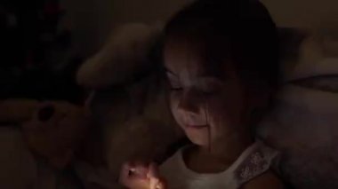 Yatakta akıllı telefon izleyen küçük kızlar, telefon ve oyun oynayan çocuklar, cep telefonu kullanan çocuklar, bağımlı oyunlar.