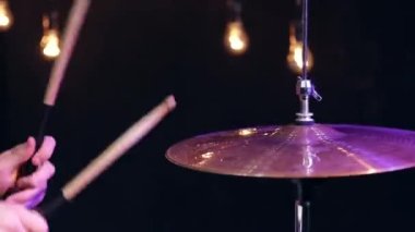 Bir adam güzel bir ışıkla karanlık bir odada sopalarla oynar..