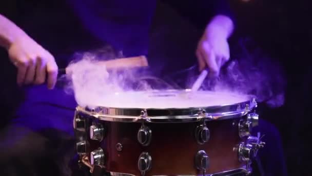 鼓手在黑漆漆的鼓上用棍棒演奏 鼓上有浓烟和美丽的灯光 — 图库视频影像