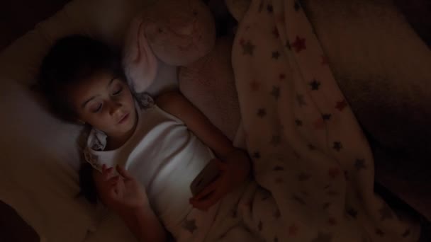 Egy Lány Fekszik Ágyban Egy Puha Játékkal Okostelefont Használ Alvás — Stock videók