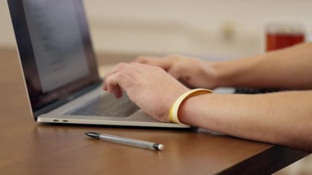 一个正在笔记本电脑上工作的年轻人在笔记本上做笔记和批注 学习和工作概念 — 图库视频影像