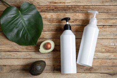 Şekerleme ve avokadoyla dolu beyaz şişelerle dolu bir hayat. Organik kozmetik ve güzellik konsepti.