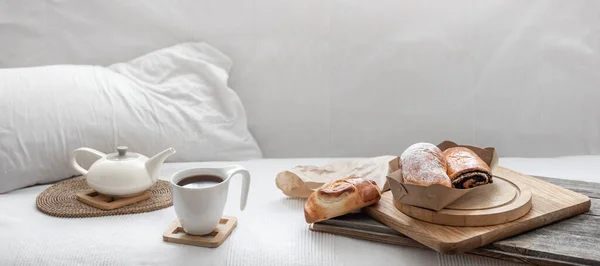 白いベッドの背景に新鮮なペストリーとコーヒーカップ ブランチと週末のコンセプト — ストック写真