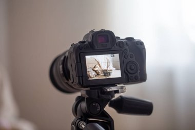 Bulanık bir arkaplanda tripodun üzerindeki profesyonel dijital kamerayı kapat. Fotoğraflar ve videolarla çalışma teknolojisi kavramı.