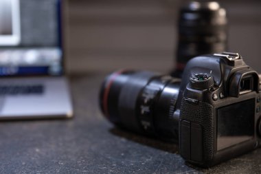 Bilgisayarlı bulanık bir arka planda profesyonel kamera. Fotoğraflar ve videolarla çalışma kavramı.