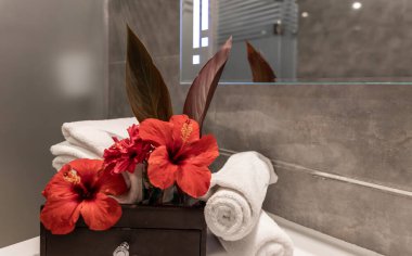 Banyoda temiz havlular ve taze çiçekler olan spa kompozisyonu..