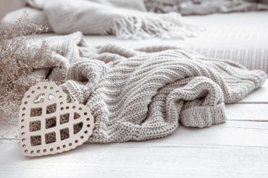 Süslü bir kalbi ve ahşap bir yüzeyde örülmüş bir elementi olan hygge tarzı bir yaşam. Ev konforu ve modern tarz kavramı.