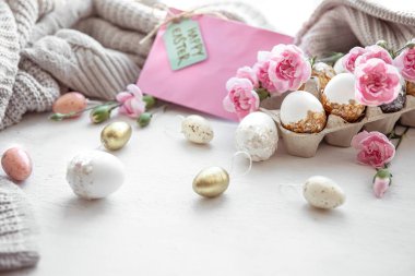 Paskalya yumurtaları, taze çiçekler ve dekoratif elementlerle dolu bir hayat..