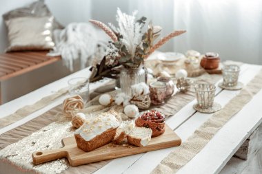 Paskalya dekorları ve şenlikli hamur işleriyle dolu bir masa. Rahat ev kompozisyonu.