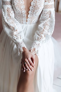 Gelinin ellerinde alyans ve boho dantelli gelinlik. Düğün fotoğrafı oturumu.