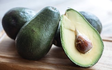 Avokadoyu kemikle kapatın. Sağlıklı ve sağlıklı gıda konsepti.