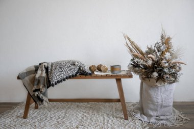 Dekoratif elementlerle İskandinav tarzında rahat bir iç tasarım ve kurumuş çiçeklerin moda bileşimi.