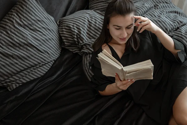 Pijamalı Çekici Genç Kadın Yatakta Yatarken Kitap Okuyor — Stok fotoğraf