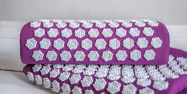 Close up massage acupuncture mat with pillow and white massage tips, massage mat for relaxation and treatment.