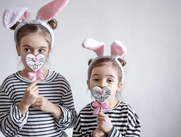 Śmieszne Dziewczynki Wielkanocnymi Uszami Głowach Wielkanocnym Piernikiem Patykach — Zdjęcie stockowe