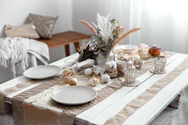 Paskalya bayramı için dekore edilmiş yemek masasında boş tabak ve bardaklar. Güzel hygge tarzı masa ayarları.