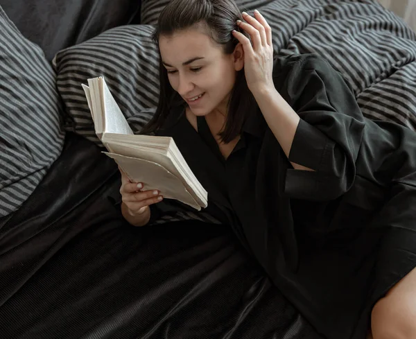 Pijamalı Çekici Genç Kadın Yatakta Yatarken Kitap Okuyor — Stok fotoğraf