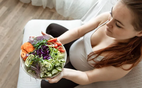 Mujer Embarazada Con Plato Ensalada Verduras Frescas Casa Sofá Vista — Foto de Stock