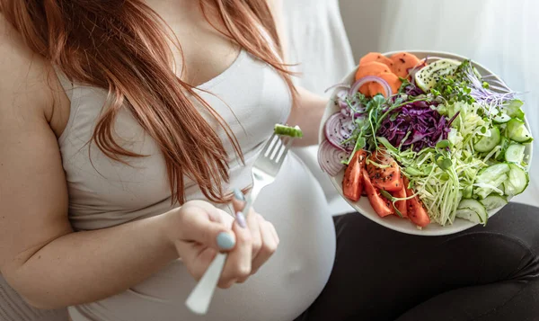 一个孕妇手里拿着一份新鲜蔬菜色拉的盘子的特写 — 图库照片