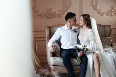 Gelin ve damadın dantel bir gelinlik içinde boho tarzında nazikçe portresi. Stüdyoda düğün fotoğrafı çekimi..