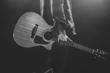 Elinde akustik gitar tutan bir adam yakına geliyor..