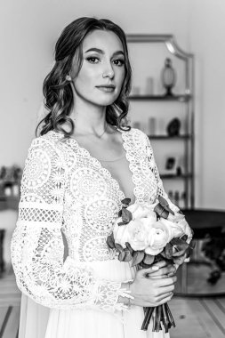 Elinde bir buket taze çiçek ve dantelli güzel bir şenlik elbisesi olan gelin. Düğün fotoğrafı, gelin sabahı..