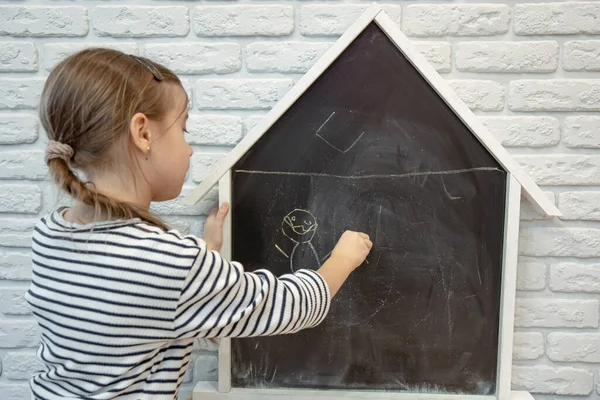 Una Niña Dibuja Una Tiza Una Pizarra Forma Casa — Foto de Stock