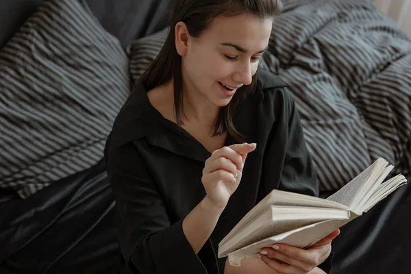 Pijamalı Çekici Genç Bir Kadın Kitap Okurken Yatakta Dinleniyor — Stok fotoğraf