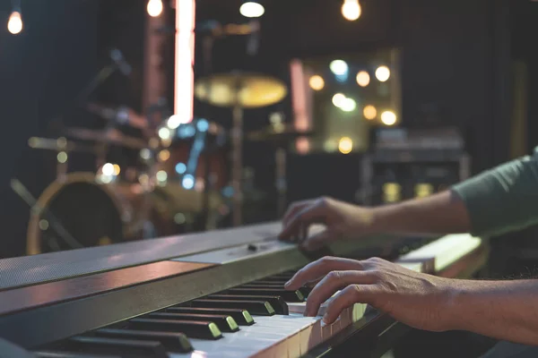 Close up of pianist\'s hand on musical keys on blurred background.