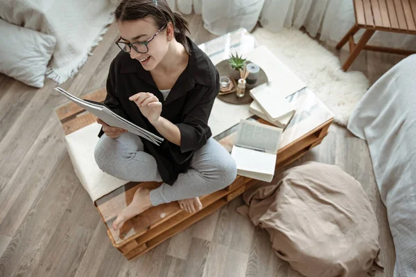 Atractiva Chica Feliz Casa Sentado Con Cuaderno Pluma Entre Los —  Fotos de Stock