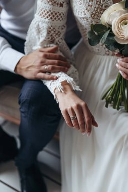 Gelin ve damadın parmaklarındaki alyansları kapatın. Düğün fotoğrafı oturumu.