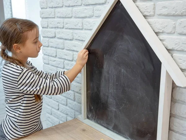 Mała Dziewczynka Rysuje Kredę Tablicy Kształcie Domu — Zdjęcie stockowe