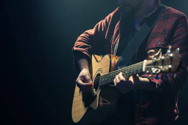 어두운 공간에서 어쿠스틱 기타를 연주하는 음악가 — 스톡 사진