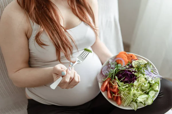 一个孕妇手里拿着一份新鲜蔬菜色拉的盘子的特写 — 图库照片