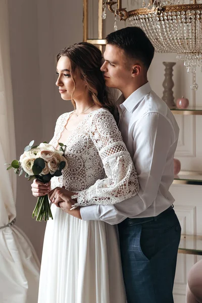 Vőlegény Gyengéden Átöleli Menyasszonyt Egy Gyönyörű Csipke Ruhában Egy Csokor — Stock Fotó