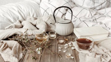 Sıcak bahar, mumlar, çaydanlık, çaydanlık, ahşap bir yüzeyde kırsal bir tarzda..