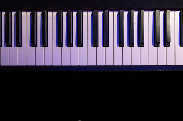 Piano keys in the dark close up and top view.