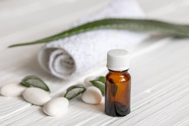 Aloe yapraklarının arka planında doğal yağ ve sağlık için havluyla birlikte doğal yağlı bir kavanozun yakın çekimi..
