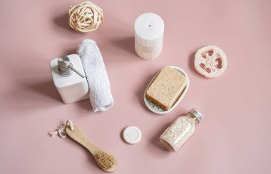 Sabun, fırça, lif, deniz tuzu ve havluyla spa kompozisyonu.