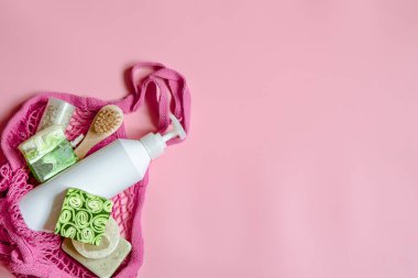 Kişisel hijyen eşyalarıyla ve banyo aksesuarlarıyla bir sicim torbasında düz bir spa kompozisyonu.