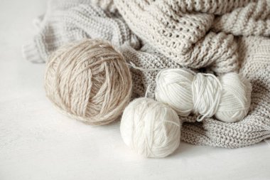 Pastel renkte iplik topları ve örülmüş rahat süveter.