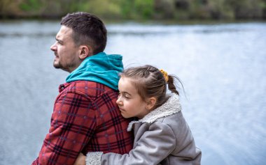 Babası ve küçük kızı baharın başında ormanın kenarında oturup doğanın tadını çıkarıyorlar..