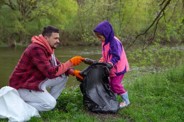Babam ve küçük kızı ormandaki çöpleri temizliyorlar..