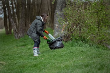Gönüllü kız ormanda çöp topluyor, çevreyle ilgileniyor..