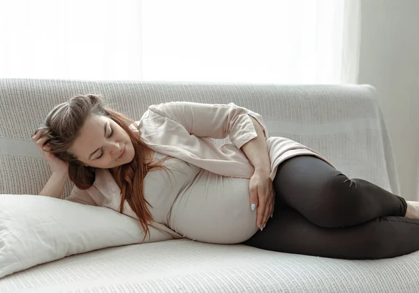 上个月 一个时髦的孕妇躺在家里的沙发上 — 图库照片